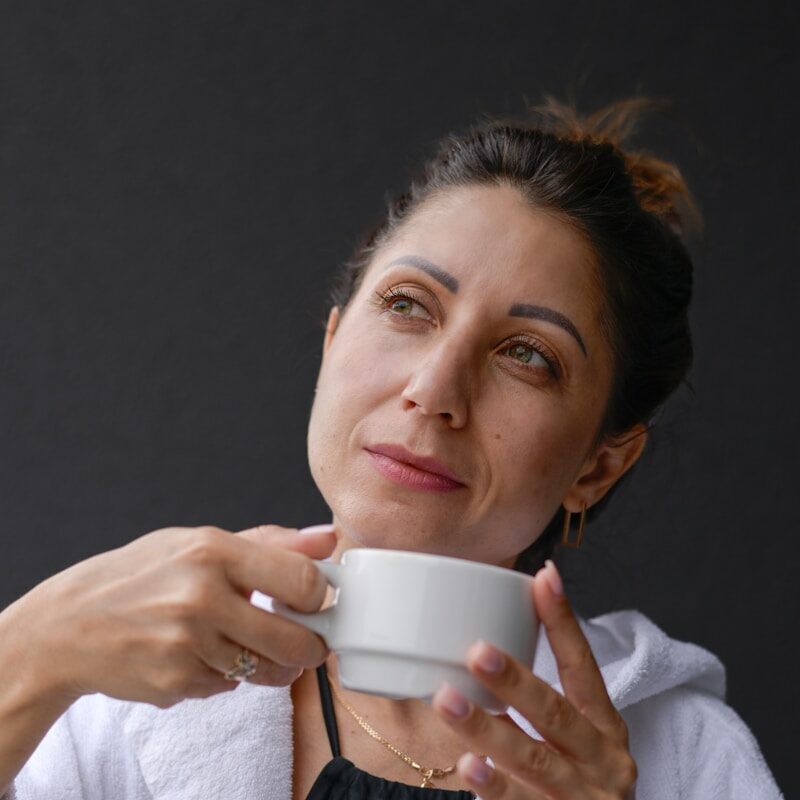 A woman is holding a cup of coffee
